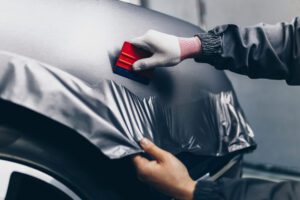 Car wrapping specialist putting car wrap vinyl foil or film on car